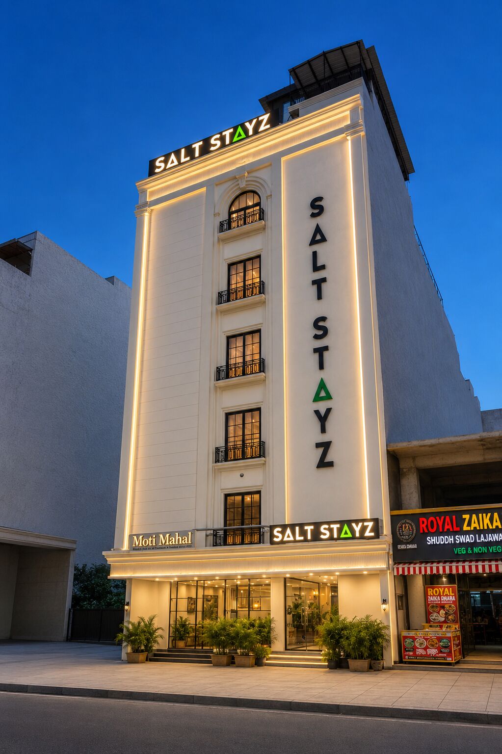 A hotel named 'Salt Stayz' with a modern facade, multiple balconies, and a sign for 'Royal Zaika' restaurant.