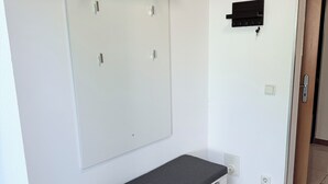 Ein Zimmer mit integriertem Sitzplatz, einer Wandablage und einer Tür mit Griff.
