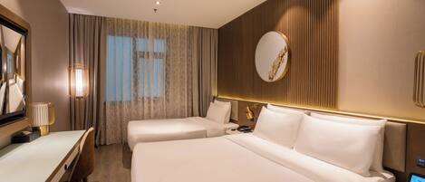 Ein Hotelzimmer mit zwei Betten, einem Schreibtisch, einem Stuhl, einem Nachttisch, einer Lampe, einem Spiegel und einer Wanduhr.