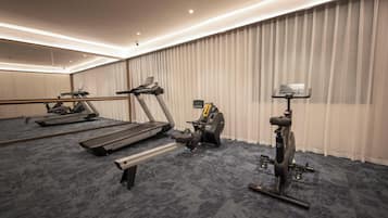 A hotel fitness room with a treadmill, elliptical, and stationary bike.