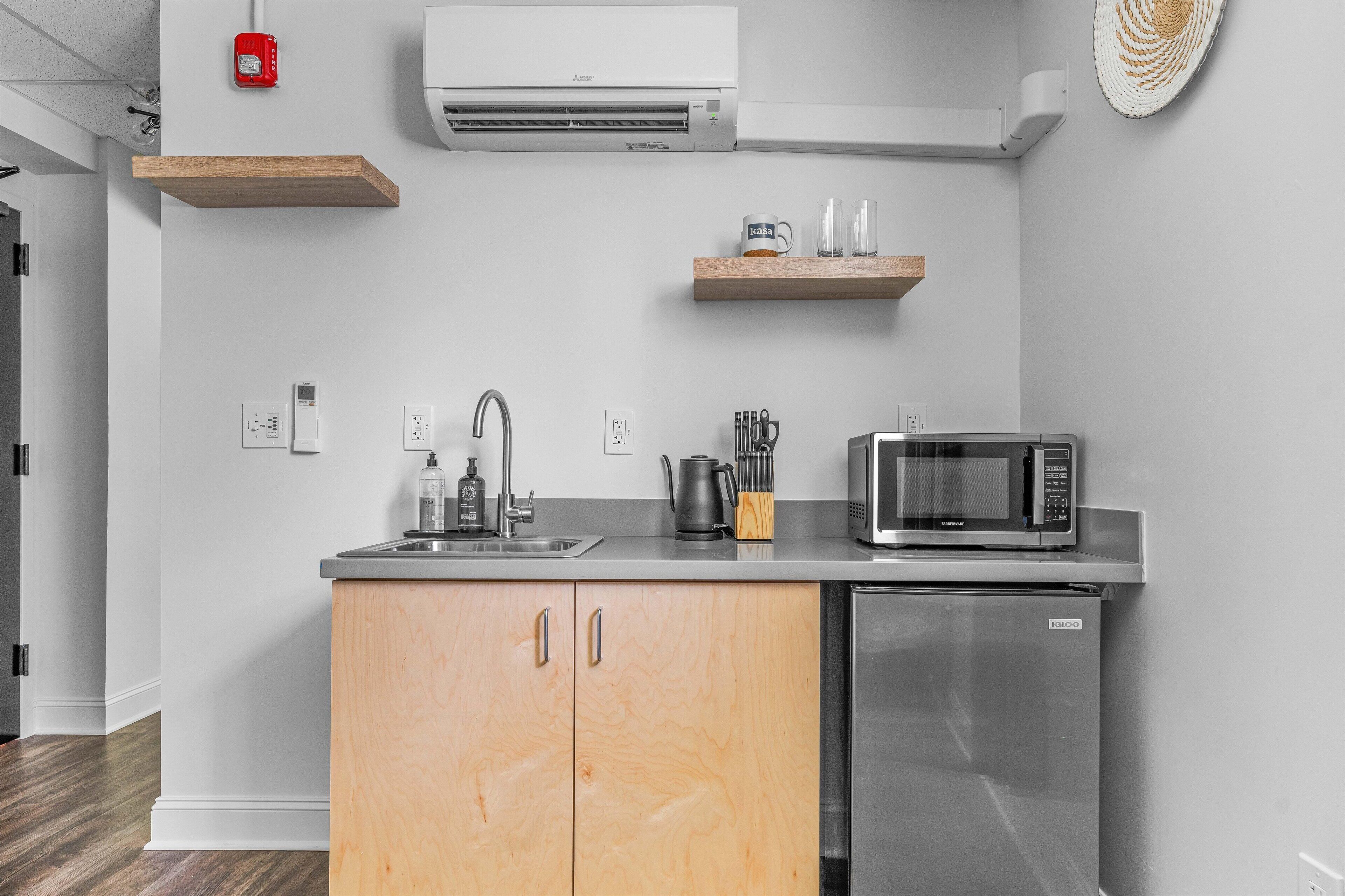A modern kitchen with a stainless steel refrigerator, a microwave, and a sink.