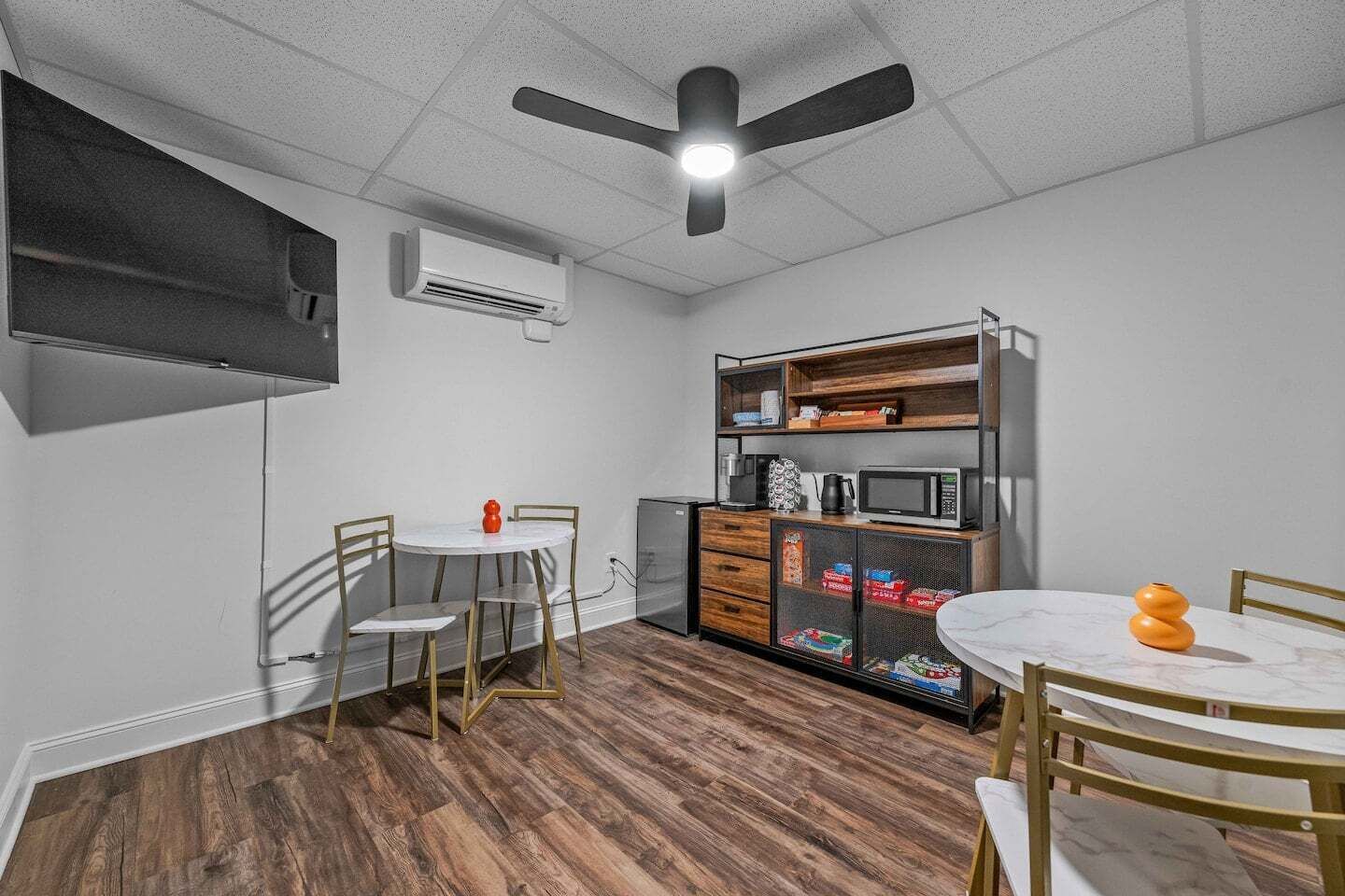 A compact kitchenette with a microwave, coffee maker, and storage cabinets.