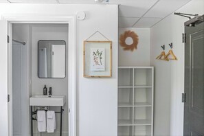 A bathroom with a mirror, sink, and framed botanical print on the wall. - Sabel #005 | Downtown Asheville with queen bed (Asheville)