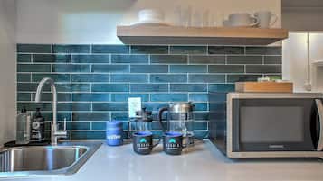 Coffee/tea maker, microwave, cookware/dishes/utensils, dining table