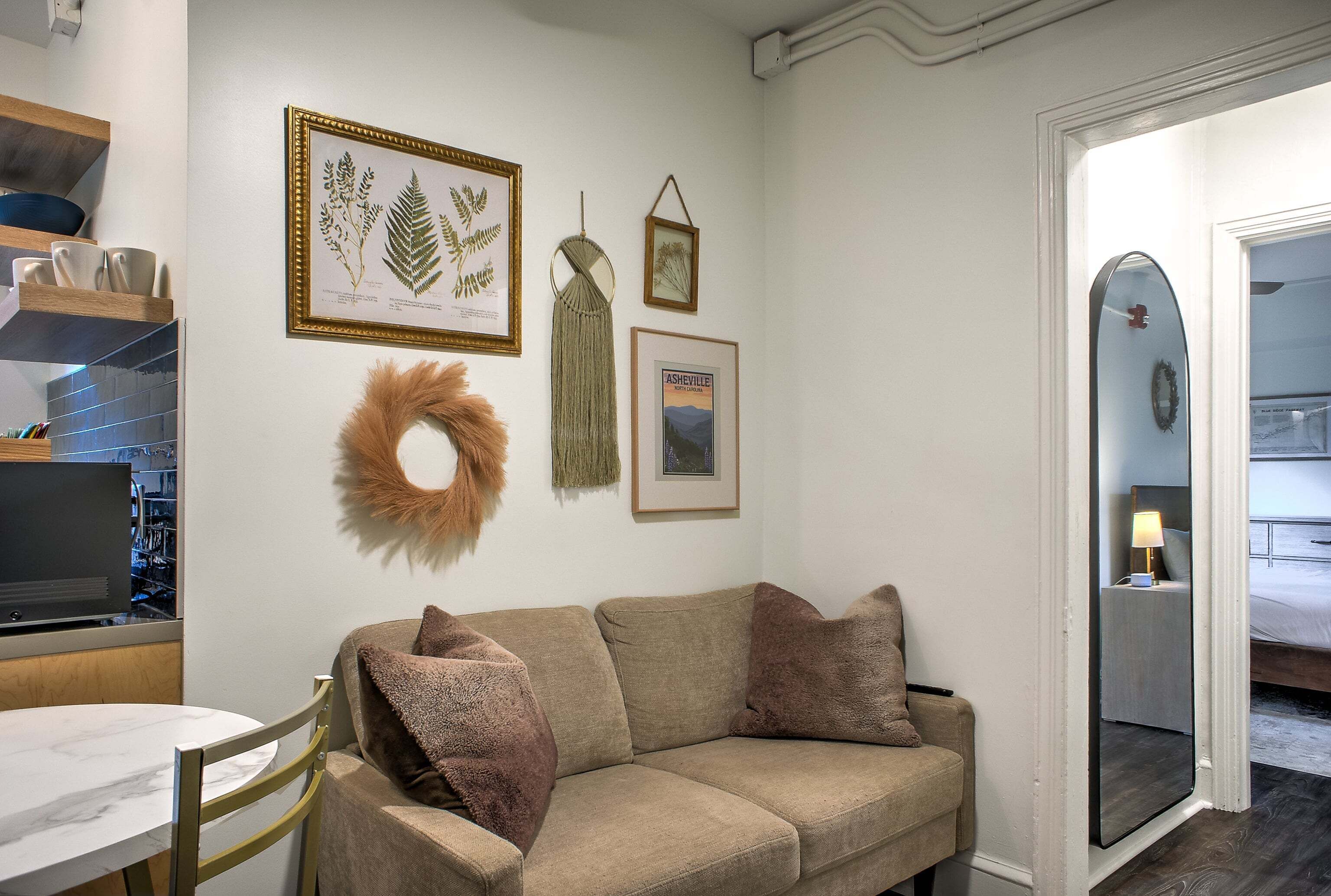 Una habitación acogedora con un sofá color beige, una mesita y un televisor.