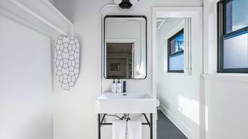 A bathroom with a white sink, a mirror, and a hexagonal wall decoration.