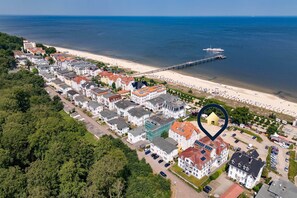 Ein Luftbild eines Küstenwohngebiets mit Häusern, einem Strand und einem Steg.