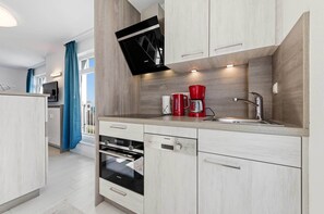 Eine moderne Küche mit Backofen, Kaffeemaschine und Spüle.