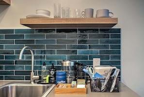 A kitchen with a stainless steel sink, a coffee maker, and a variety of kitchen utensils. - Sabel #303 | Downtown Asheville king suite with kitchenette, Wi-Fi, parking. (Asheville)