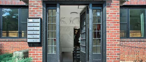 A building entrance with a numbered door, a mailbox, and a small step leading up to the door.