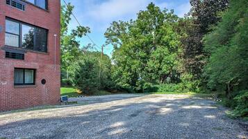 A gravel driveway leading to a brick building with multiple windows.