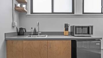 Coffee/tea maker, microwave, cookware/dishes/utensils, dining tables