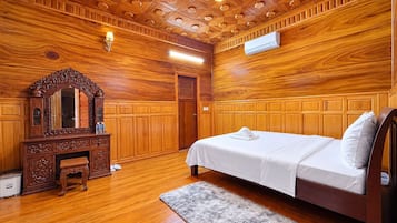 A wooden-paneled room with a bed, a dresser, and a mirror.