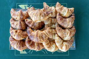 A tray of golden-brown pastries with a flaky texture, arranged on a dark surface. - Alivella (Naples)