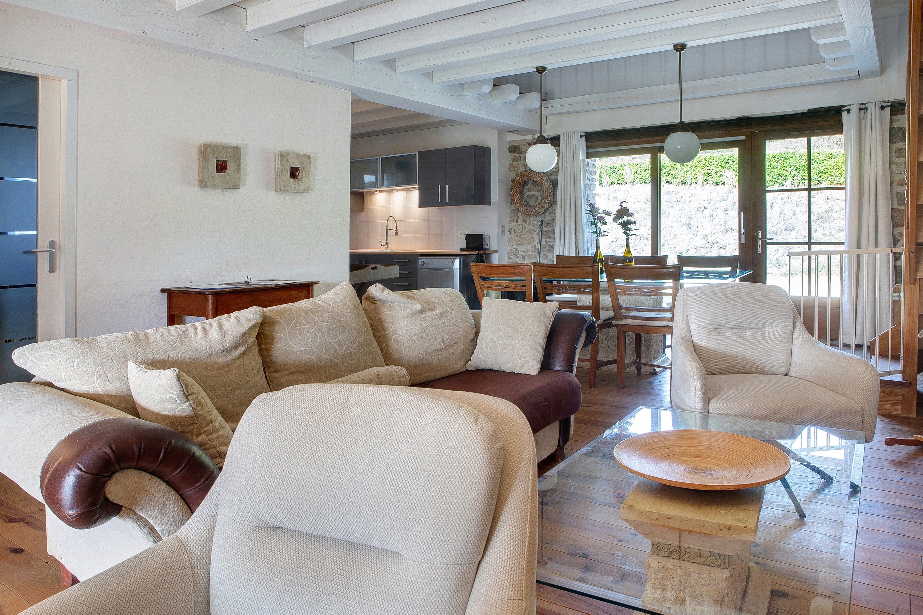 A spacious living area with a sofa, a coffee table, and a dining table set for two.
