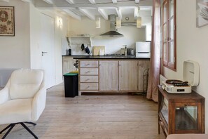 Een keuken met houten kastjes, een zwarte prullenbak en een vintage radio.