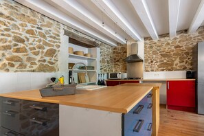 A kitchen with stone walls, wooden countertops, and modern appliances. - Holiday Home 'Domaine De Bellac - La Belle Cour' with Shared Pool, Garden & Wi-Fi (Roussines)