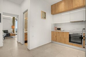 Une cuisine moderne avec des meubles en bois, un four encastré et un plan de travail en marbre.