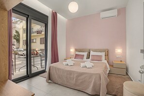 Et hotelværelse med en seng, sengeborde, et vindue med udsigt til gaden og en aircondition.