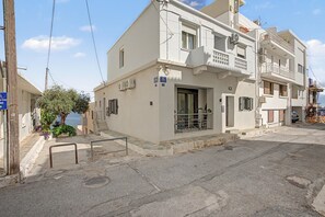A two-story building with a balcony, a sign indicating a hotel, and a view of the sea. - Apartment 'Sea View Uno 1' with Sea View, Wi-Fi and Air Conditioning (Agios Nikolaos)