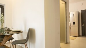 A modern kitchen with a built-in refrigerator and a dining area with a table and chairs. - Apartment 'Sea View Uno  1' with Sea View, Wi-Fi and Air Conditioning (Agios Nikolaos)