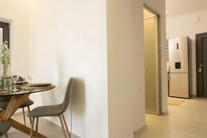 Eine moderne Küche mit integriertem Kühlschrank und einem Essbereich mit Tisch und Stühlen.