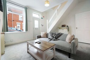A modern living room with a sofa, a coffee table, and a staircase. - Cosy Blackhall 2BR Sleeps 5 By Stay With Us (Blackhall Colliery)