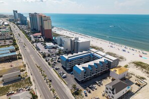 A coastal hotel with a beach view, multiple floors, and a parking lot. - Gulf-view condo steps from the beach Regatta 102a (Gulf Shores)