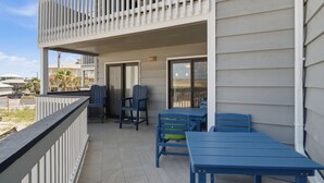 A balcony with a railing, two chairs, and a table. - Gulf-view condo steps from the beach Regatta 102a (Gulf Shores)