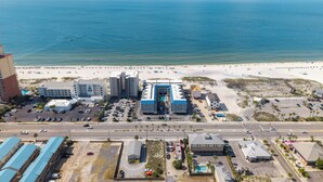 A coastal hotel with a beach view, parking, and a road leading to the beach. - Gulf-view condo steps from the beach Regatta 102a (Gulf Shores)