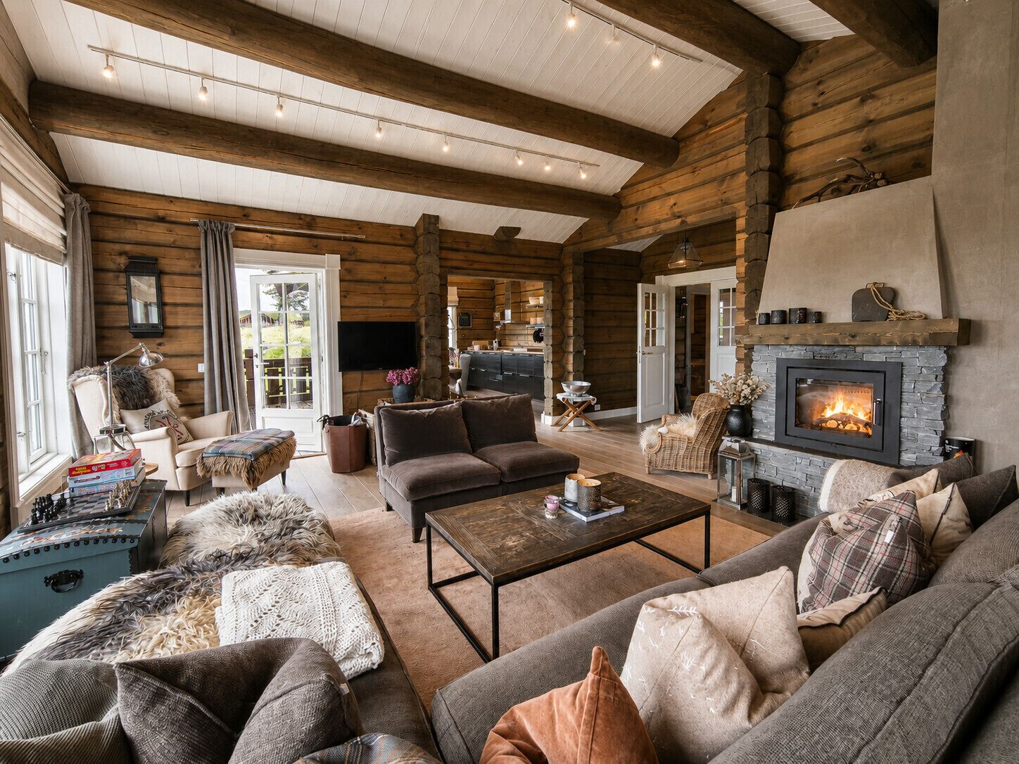 A spacious living area with a fireplace, sofas, and a television.