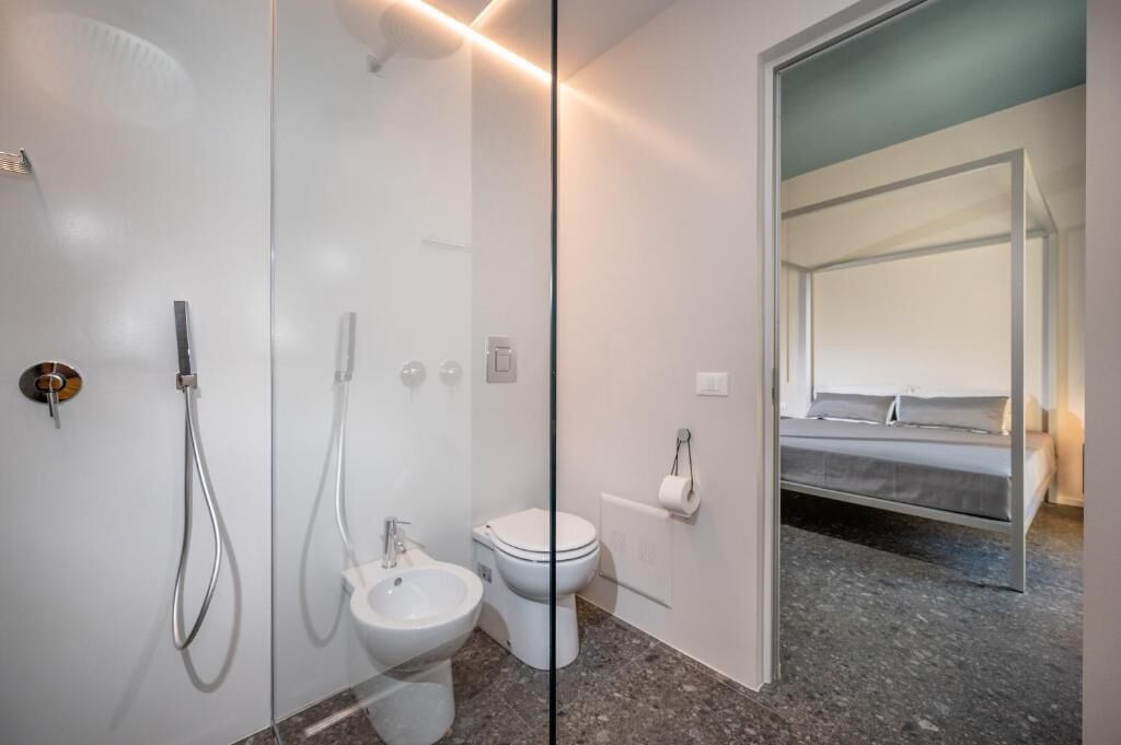 Un baño moderno con cabina de ducha de vidrio, un bidé y un inodoro.