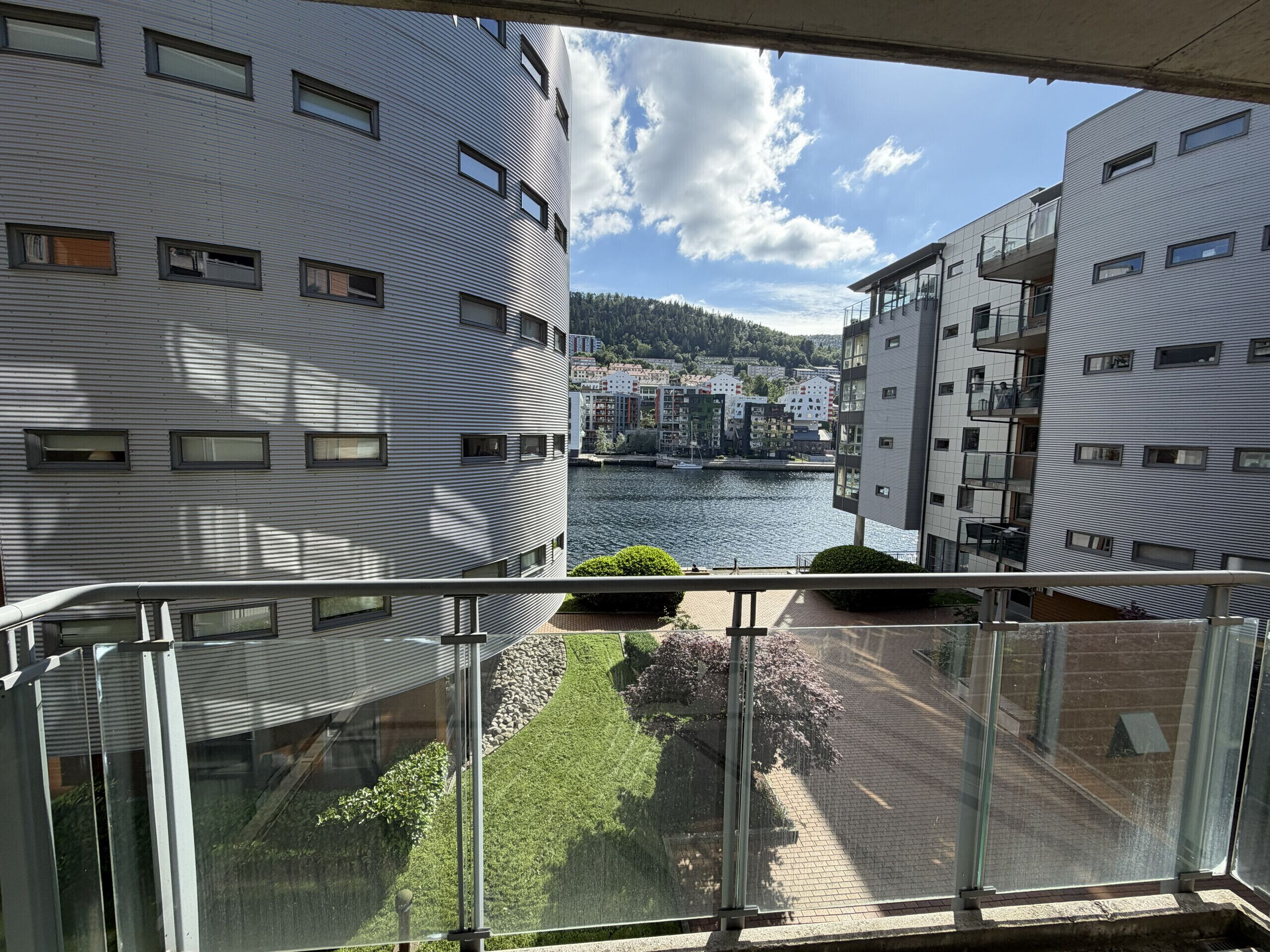 Un bâtiment moderne offrant une vue sur une rivière et d’autres immeubles en arrière-plan.
