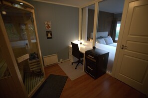 Ein Schlafzimmer mit einem Bett, einem Schreibtisch, einem Stuhl, einem Kleiderschrank und einem Marshall Verstärker.