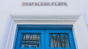 Una puerta azul con un letrero que dice 'TRAFALGAR FLATS'.