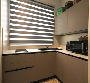 A compact kitchen with a built-in microwave, a kettle, and a bread container on the shelf. - SIX • Birgu - 3-bed 3-bath luxury Marina Residence - Valletta ferry (Birgu)