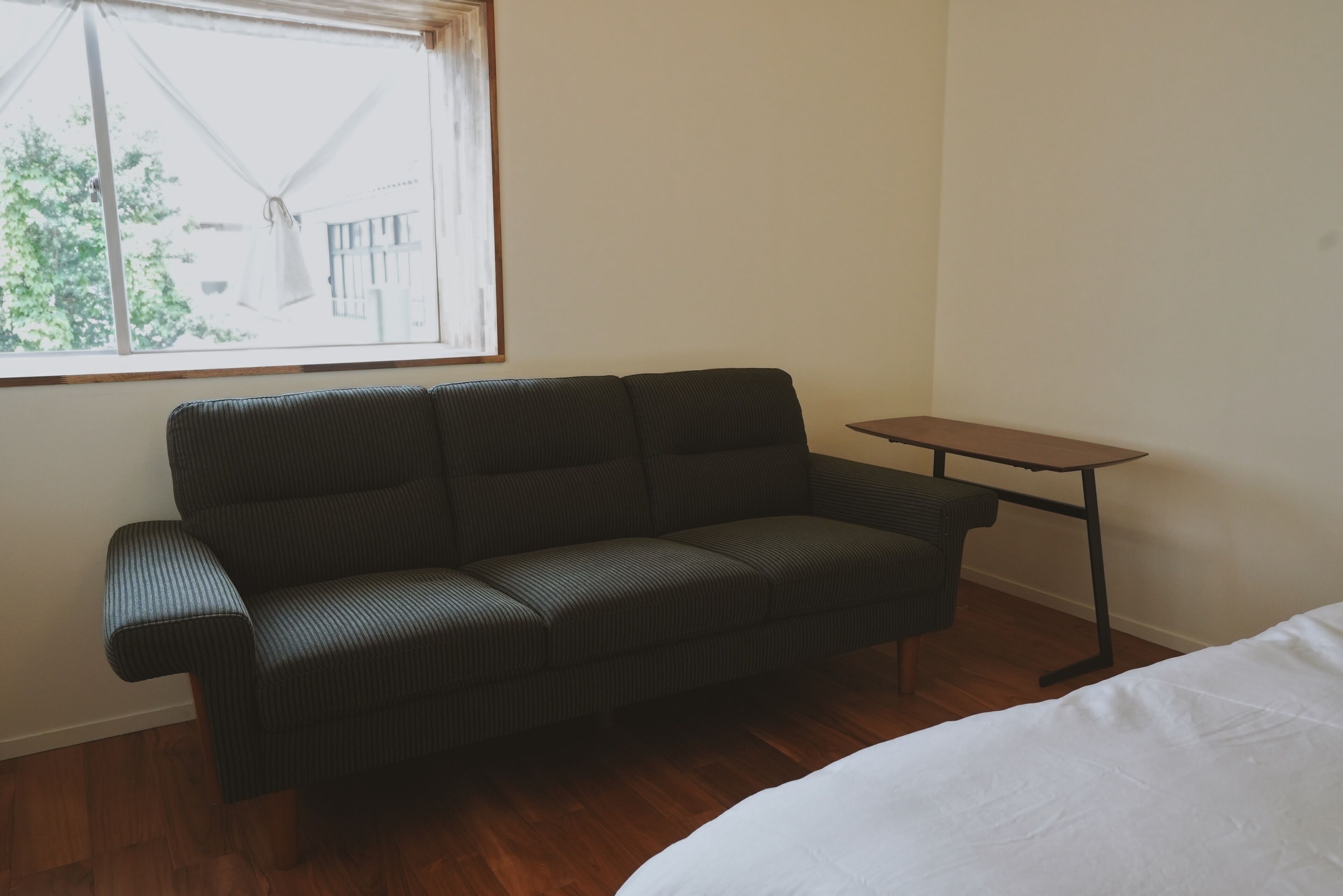 A room with a sofa, a small table, and a window.