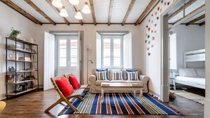 A spacious living room with a wooden floor, a sofa set, a coffee table, and a bookshelf. - Apartment 'Dazzling House Alentejo' with Private Terrace, Wi-Fi and Air Conditioning (Reguengos de Monsaraz)