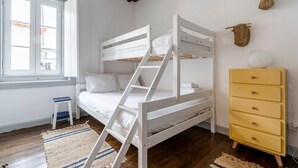 A bunk bed with a ladder, a small stool, a yellow dresser, and a window with a view. - Apartment 'Dazzling House Alentejo' with Private Terrace, Wi-Fi and Air Conditioning (Reguengos de Monsaraz)