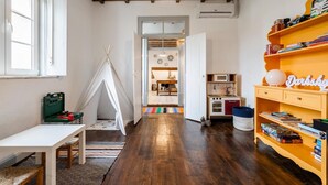 A child's playroom with a tent, a bookshelf, and a kitchen area. - Apartment 'Dazzling House Alentejo' with Private Terrace, Wi-Fi and Air Conditioning (Reguengos de Monsaraz)