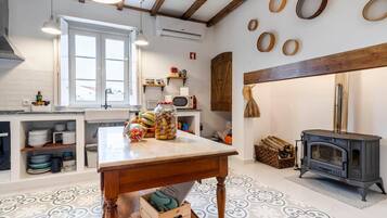 A kitchen with a wooden table, a stove, and various kitchen items.