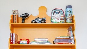 A wooden desk with multiple shelves holding books, puzzles, and a toy car. - Apartment 'Dazzling House Alentejo' with Private Terrace, Wi-Fi and Air Conditioning (Reguengos de Monsaraz)