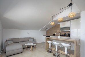 Eine moderne Küche mit Holzarbeitsplatte, einem Einbauofen und einer weißen Bar mit Hockern.