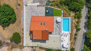 An aerial view of a property with a swimming pool, a covered patio, and a fenced yard. - Holiday Home Elora Seaview Private Pool And Garden (Kostrena)