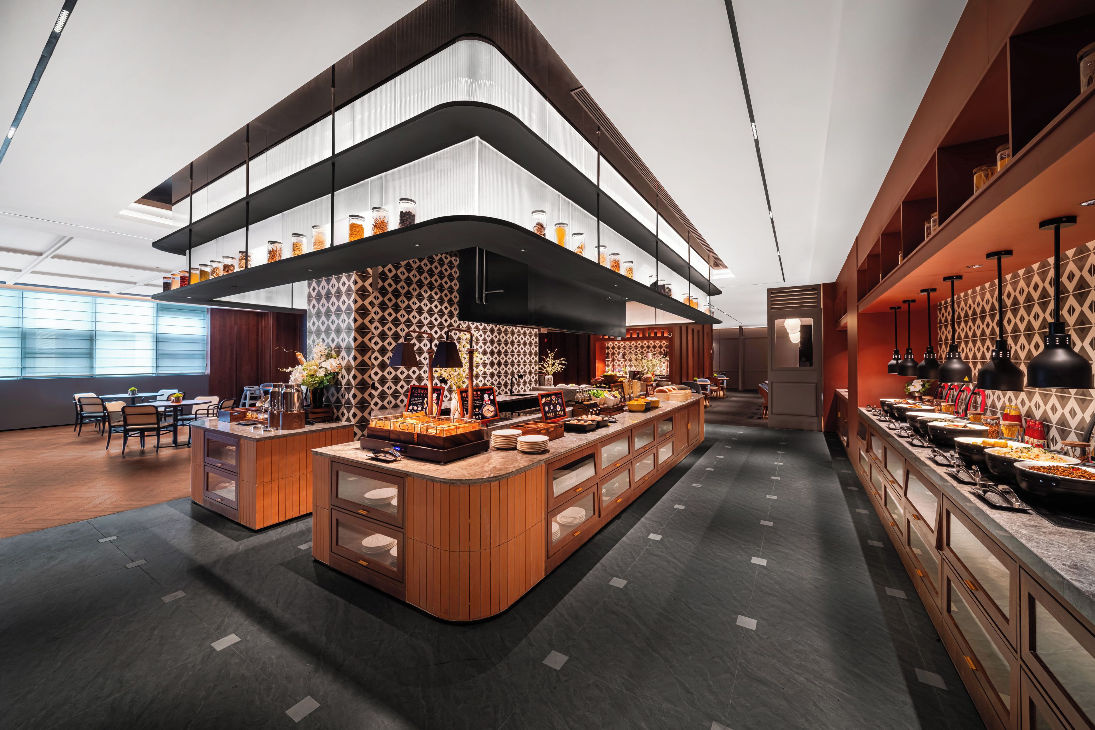 A modern restaurant interior with a central island, high ceilings, and a variety of seating arrangements.