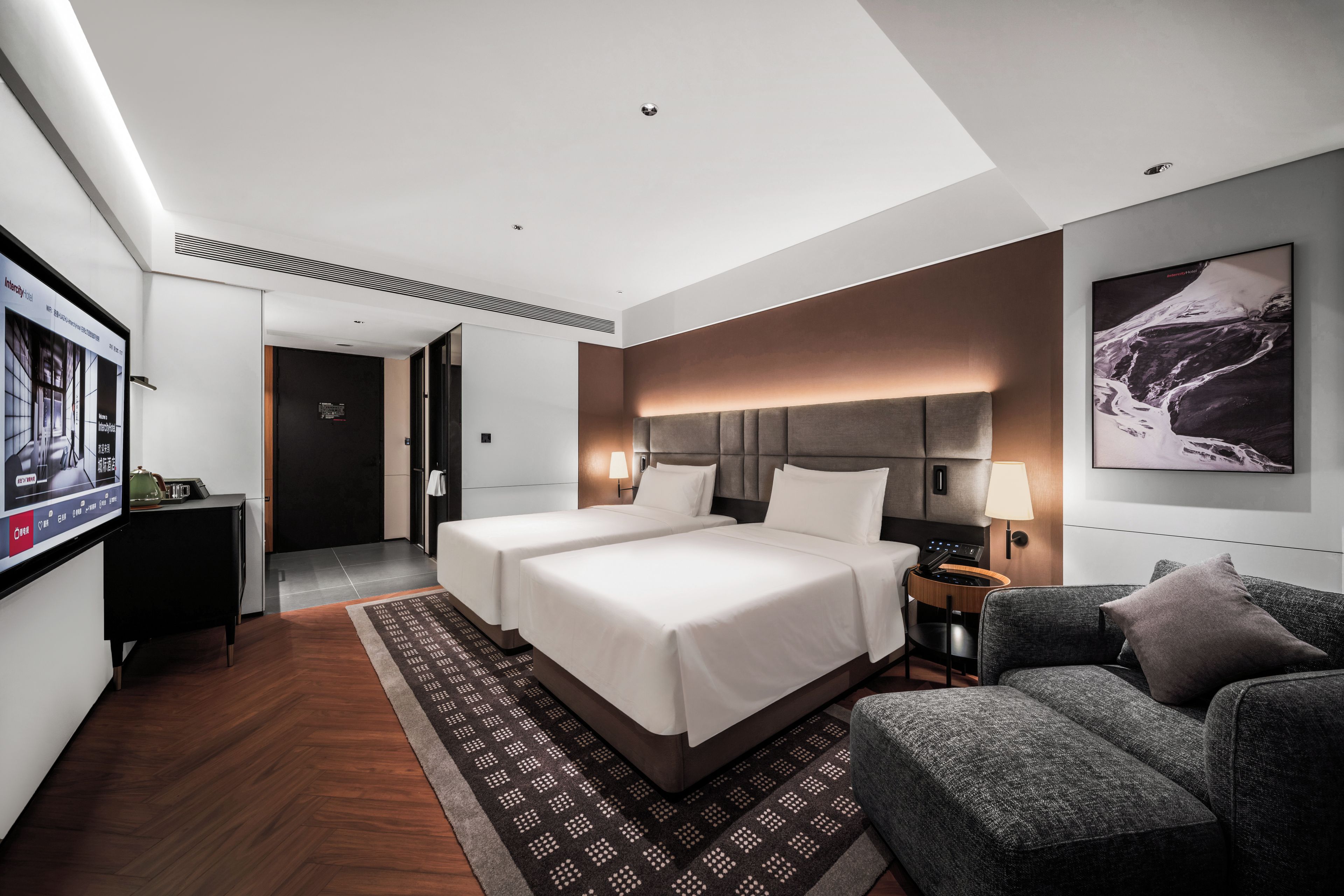 A hotel room with a large bed, two bedside tables, a desk, a chair, and a TV.