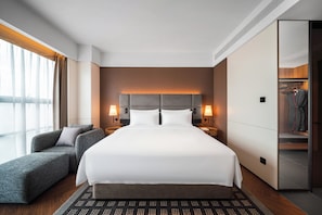 A modern hotel room with a large bed, a seating area, and a walk-in closet. - Shanghai Intercity Expo Center Hotel (Shanghai)