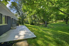 Un immobile residenziale con patio coperto, prato e recinzione.