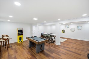 Una stanza con tavolo da biliardo, sala giochi Pac-Man e tavolo accessibile in sedia a rotelle.