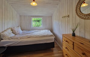 Ein Schlafzimmer mit einem Bett, einem Schminktisch, einem Fenster und einem Spiegel.